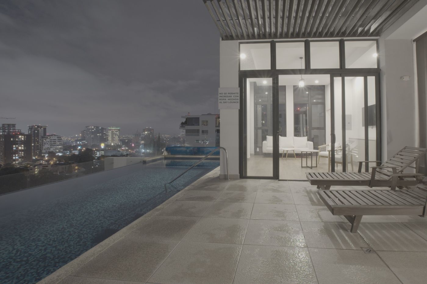Flat unedited image: Rooftop pool beside the lit lounge