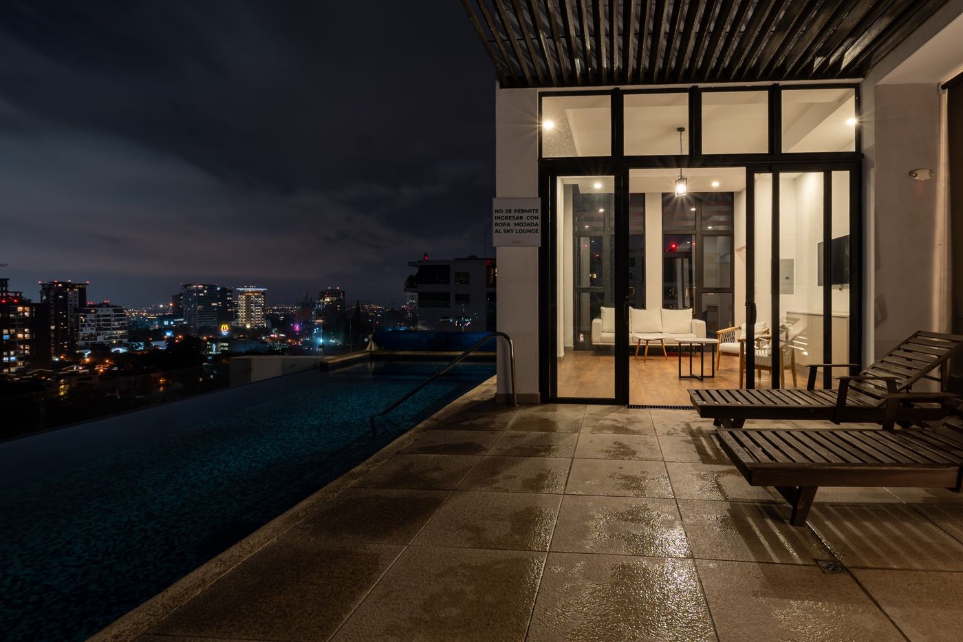 Final photo: Rooftop pool beside the lit lounge