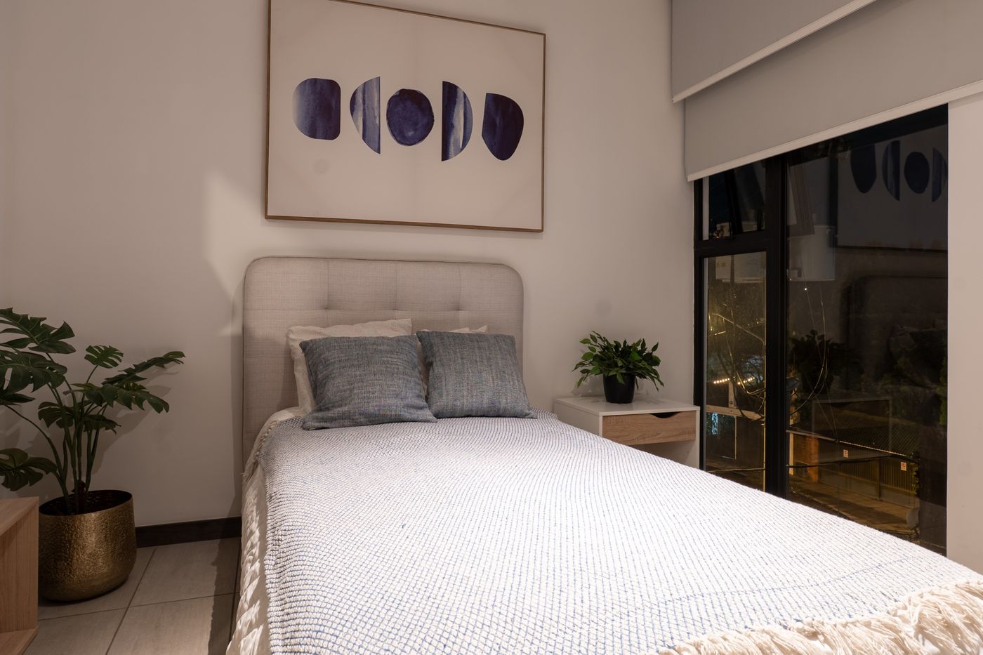 Final photo: Bedroom with blue artwork and plants