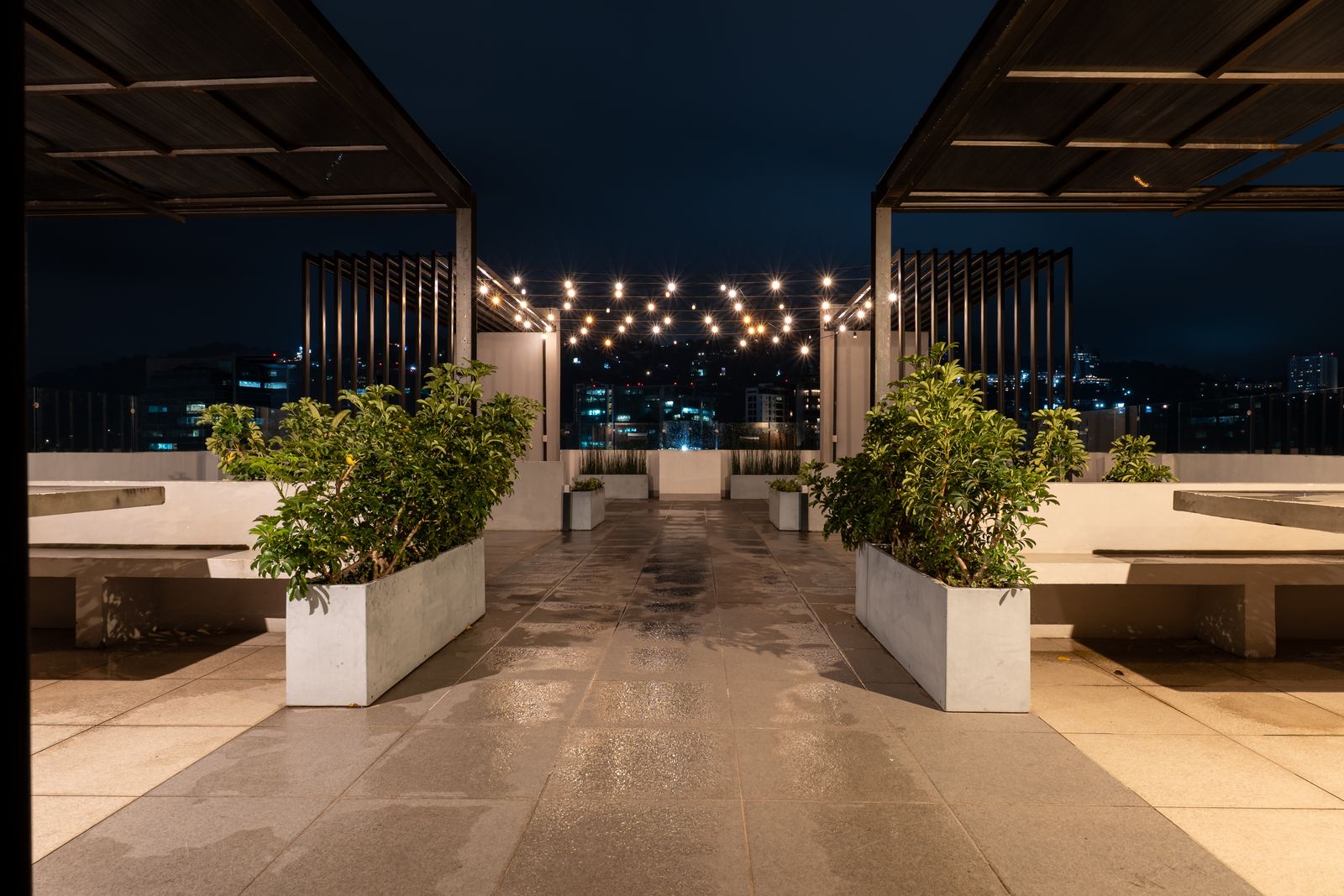 Terrace with planters and lights in the distance