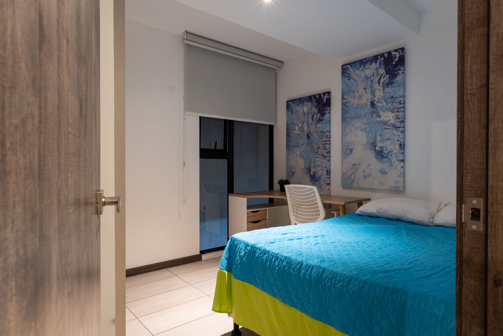 Bedroom with a desk and blue bedding