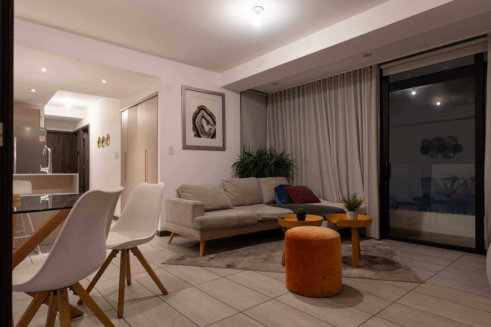 Living room with an orange pouf and wall art